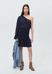 Mornarsko enostransko obleko z oprijetim zgornjim delom in razširjenim robom. Nosi se s svetlo modro kavbojko, rjavimi gležnjači in preprostim nakitom.