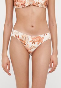 Dámske kvetinové bikiny s farbami broskyne a smotany, s hladkou textúrou, nízkym strihom a jemnými bočnými švami.