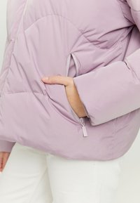 Light purple puffer jacket with a quilted design, featuring a zippered pocket on the side and elastic cuffs for a snug fit.