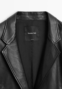 Zwarte leren blazer met een gestructureerde kraag, ingesneden revers en een zijden zwarte voering. Beschikt over een geweven label met de tekst "Massimo Dutti."