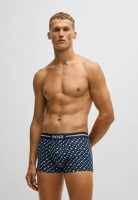 Navy patterned boxer briefs featuring a geometric design, elastic waistband with "BOSS" logo, soft fabric, and fitted shape.