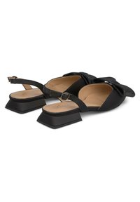 Scarpe slingback nere con punta quadrata, dettagli in tessuto testurizzato a forma di fiocco e tacco quadrato chunky. Fodera interna liscia e cinturino regolabile.