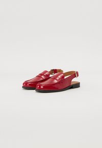 Scarpe slingback in pelle verniciata rossa con punta arrotondata, caratterizzate da un dettaglio cucito sulla tomaia e una suola nera piatta.