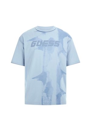 Light blue short-sleeve t-shirt featuring a textured "GUESS" logo and abstract pattern in a slightly darker blue tone.