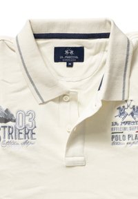 Koszulka polo z kremowej bawełny z kołnierzykiem, dwoma guzikami oraz haftowanymi detalami, w tym "03", górami i logo marki.