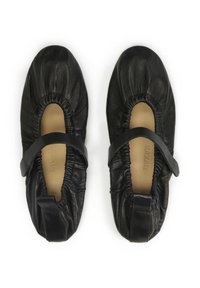 Ballerines en cuir noir avec un design froncé, des ouvertures élastiquées et une sangle sur le cou-de-pied. Doublure intérieure douce.
