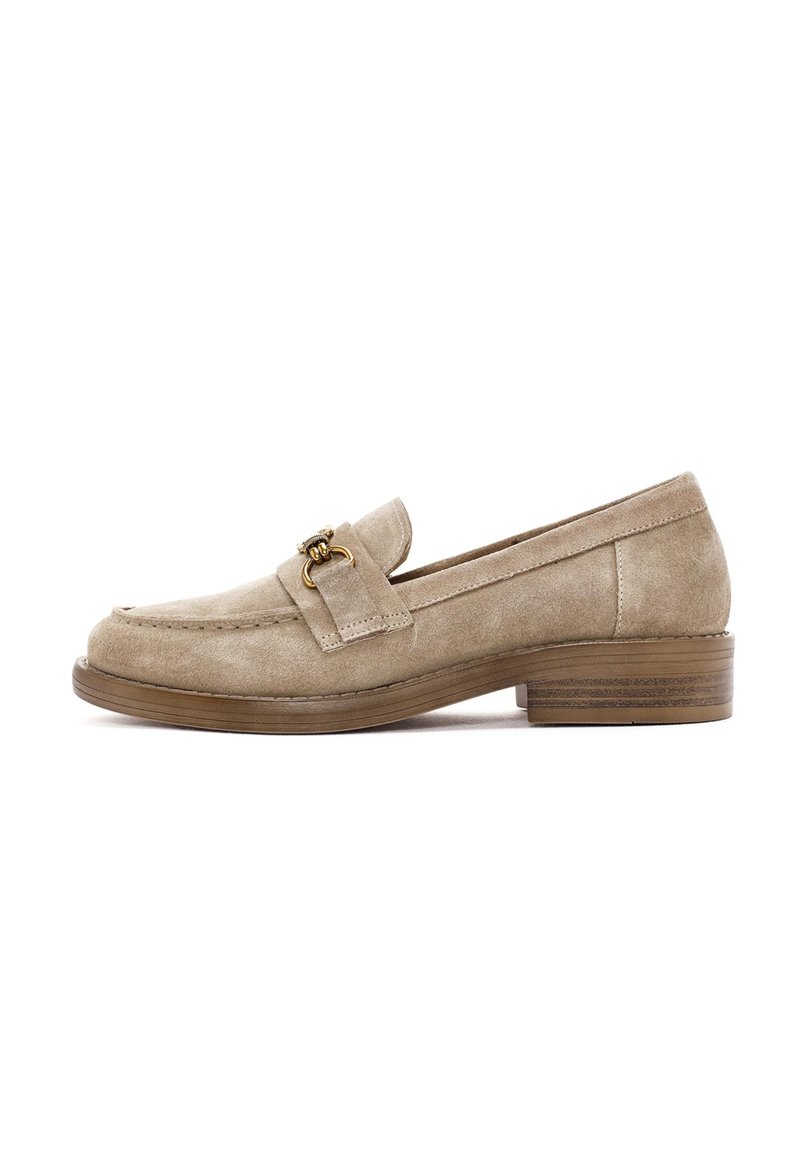 Beige suede loafer with a rounded toe, stitch detailing, and a gold-toned accent on the strap. Low wooden heel, textured surface.
