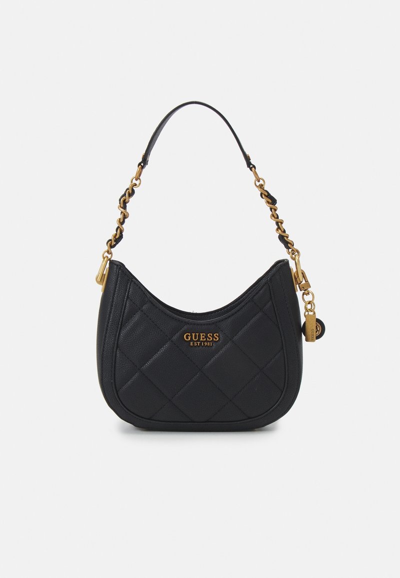 Sac à épaule noir matelassé avec chaînes dorées, logo GUESS en or et petites étiquettes suspendues sur fond uni.