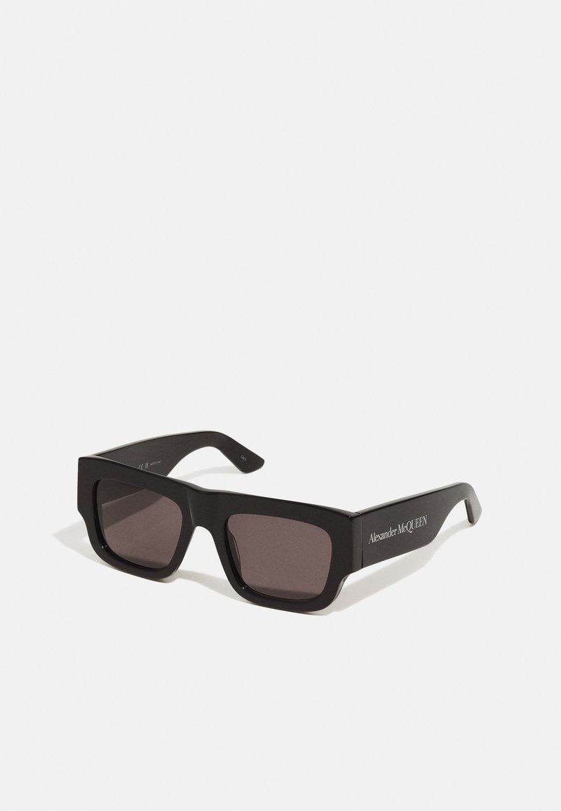 Black rectangular sunglasses with dark lenses, thick plastic frame, and a logo printed on the temple. Smooth finish with no visible patterns.