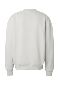 Suéter blanco liso de manga larga con cuello redondo, puños y dobladillo acanalados, visto desde atrás.