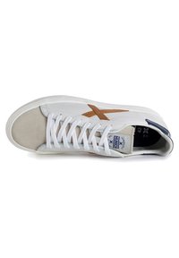 Sneaker bianca con accenti in suede marrone e logo beige. Presenta una chiusura con lacci, colletto imbottito e suola in gomma strutturata. Taglia 42.