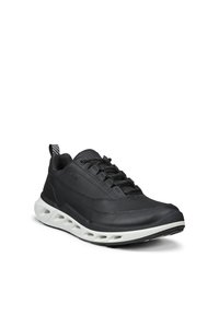 Zwarte lage sneaker met een vetersluiting aan de voorkant, ademend bovenwerk en een witte, gevoerde zool met ventilatieopeningen, schuin naar rechts gericht.