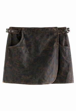 Tablier en simili cuir brun avec deux poches latérales, un ourlet arrondi et des accents en métal. Surface texturée avec des motifs de rayures distinctifs.