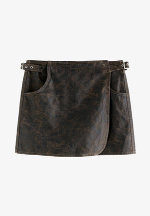 Tablier en simili cuir brun avec deux poches latérales, un ourlet arrondi et des accents en métal. Surface texturée avec des motifs de rayures distinctifs.