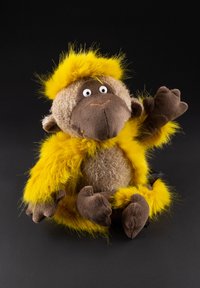 Stuffed monkey with a fluffy yellow mane, brown body, and soft brown limbs. Notable facial features include large eyes and a stitched smile.