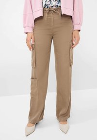 Khaki cargobroek met een relaxte pasvorm, voorzien van twee zijzakken en een strikceintuur. Soepele stof met een licht glanzende textuur.