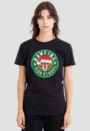 Black cotton t-shirt featuring a circular graphic of a tiger wearing a Santa hat, outlined in green with "HAWKINS HIGH SCHOOL" text.