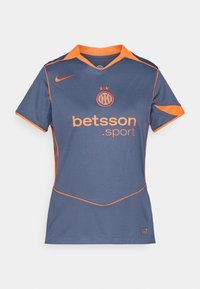 Mörkblå sporttröja med orange detaljer. Har en V-ringad krage, korta ärmar och "betsson.sport"-logotypen framtill.