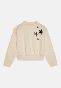 Sudadera beige con cuello redondo y dobladillo acanalado. Presenta aplicaciones de estrellas negras con lentejuelas en la parte superior izquierda. Tejido suave y texturizado.