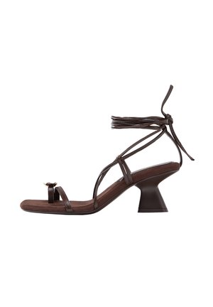 Sandalo marrone con cinturini, punta quadrata, tacco basso svasato, arricciatura per l'alluce e lacci da avvolgere alla caviglia su sfondo bianco.