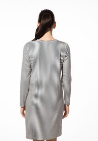 Gestreepte jurk met lange mouwen, met verticale blauwe en beige strepen. Zachte stof en ronde halslijn, knielange snit.