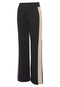 Schwarze weite Hose mit elastischem Bund und zwei beigen Seitenstreifen. Hergestellt aus weichem Stoff mit sichtbaren Nahtdetails.