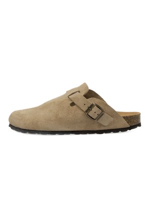 Zueco beige de ante sin cordones con hebilla lateral, plantilla de corcho y suela de goma negra, mostrado de lado sobre fondo blanco.