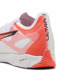Baskets blanches avec des accents rose-orange, partie supérieure en maille texturée, détails noirs et talon profilé avec technologie ProFoam Lite.
