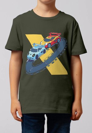 Zwei stilisierte Rennwagen, einer rot und einer hellblau, die auf einer kreisförmigen Rennstrecke vor einem gelben geometrischen Hintergrund auf einem olivgrünen T-Shirt fahren.