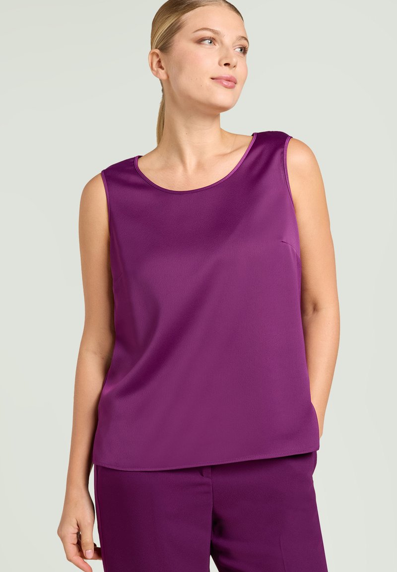 Paarse mouwloze top van een gladde, matte stof met een ronde hals en een losse pasvorm, gecombineerd met bijpassende broek.
