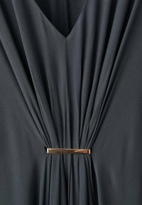 Robe gris foncé en tissu plissé avec un col en V. Elle présente un détail métallique doré à la taille, ajoutant une touche de design élégant.