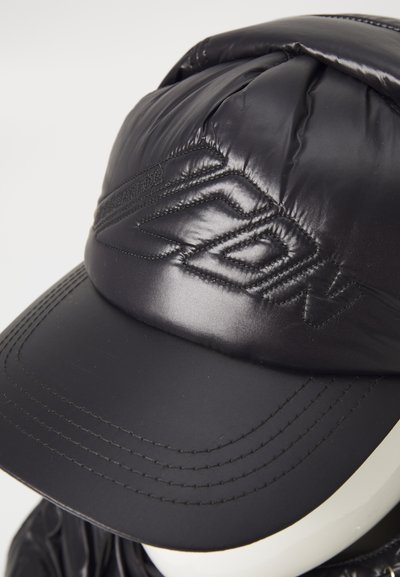 Cappello puffer nero con parte superiore bombata e imbottita e visiera piatta. Presenta cuciture tono su tono e un logo ricamato sul davanti.