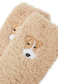 Calze pelose color cammello con una texture morbida, caratterizzate da una faccia di cane ricamata in beige e bianco su ogni lato.