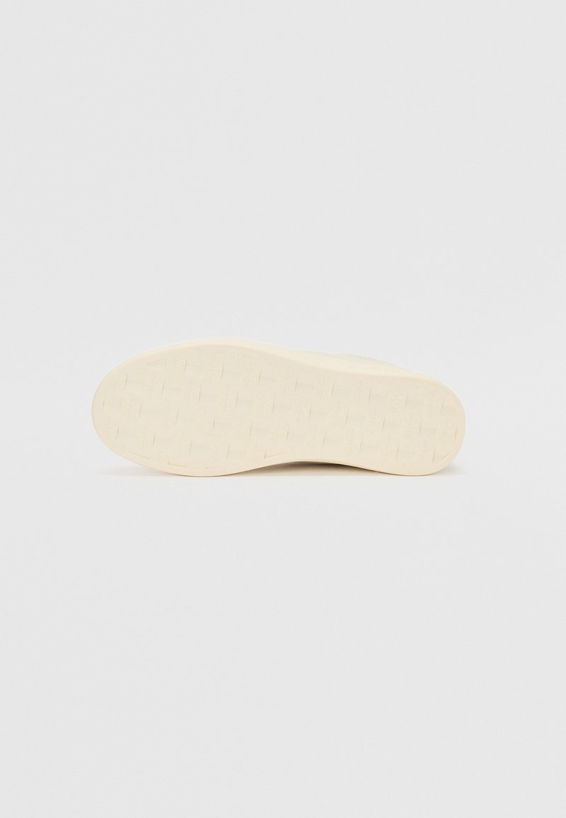 Podeszwa buta z teksturowaną, wzorzystą powierzchnią w kolorze off-white, z gładkim brzegiem i lekkim wygięciem dla komfortu.