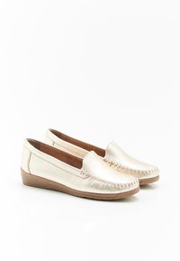 Mocassini in oro metallico con dettagli cuciti, suole piane in gomma e finitura in pelle liscia. Design slip-on con punta arrotondata.