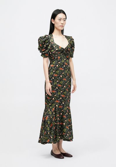 Robe fleurie avec des manches bouffantes, fond noir, fleurs multicolores vibrantes, corsage ajusté, jupe évasée, texture de tissu douce, associée à des ballerines.
