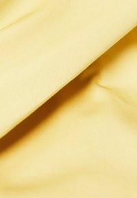 Tissu jaune clair avec une texture lisse et côtelée, présentant un léger éclat et des plis doux. Idéal pour les vêtements ou les revêtements de meubles.