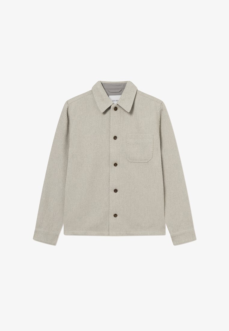 Lys grå corduroyjakke med krave, brune knapper, en enkelt brystlomme og lige snit.