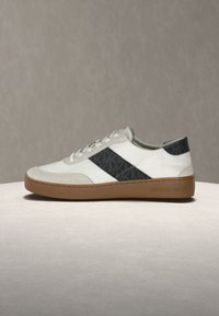 Ténis brancos e pretos com painel lateral texturizado com logótipo, detalhes em camurça, biqueira arredondada e sola de borracha castanha.