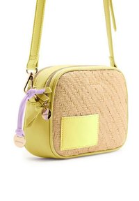 Bolso cruzado amarillo con un frente de paja trenzada, lados de cuero amarillo liso, doble cremallera y un detalle decorativo de correa púrpura.