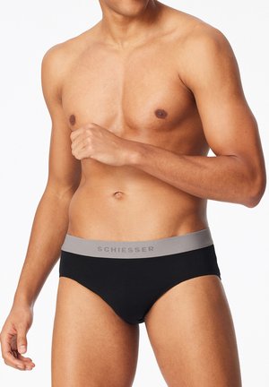 Schwarze Baumwollslips mit einem grauen Bund, der das "Schiesser"-Logo trägt. Das Design ist schlicht und figurbetont, wodurch ein klassischer Stil betont wird.