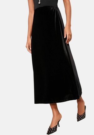 Melnas samta maxi svārki ar gludu tekstūru un drapēta dizaina. Nēsāti ar melnām punktiņu ikru kurpēm, ar norādītu purngalu un  stiletto papēdi.