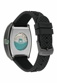 Reloj de titanio con una esfera rectangular, dial azul y fondo transparente. Presenta una correa de goma negra texturizada y un acento verde en la corona.