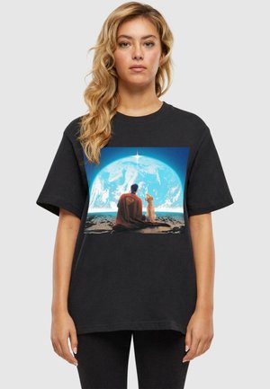 Black cotton t-shirt featuring a front graphic of a figure and dog against a blue celestial background, capturing a serene moment.