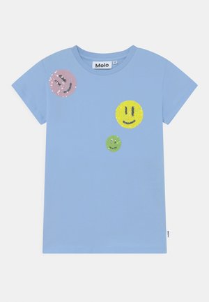 Lyseblå kortærmet skjorte med tre palietbelagte smiley-ansigter i pink, gul og grøn på forsiden.