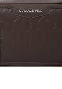 Barna textúrájú műbőr táska, amely kidomborodó geometrikus mintákkal és ezüst "KARL LAGERFELD" logóval rendelkezik az elején. Téglalap alakú.