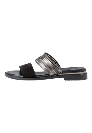 Sandale plate noire avec deux brides, une en daim noir et une métallisée texturée, avec un petit talon sur fond blanc.