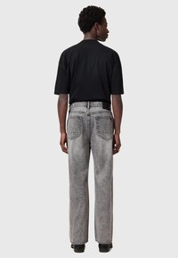 Gray denim jeans with a straight leg design, high waist, and two back pockets, paired with a black short-sleeve shirt.