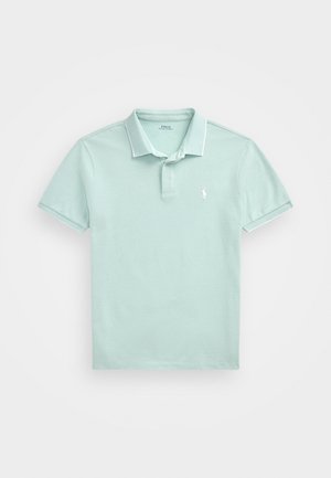 Polo bleu clair en coton texturé, avec un col classique, des manches courtes et un petit emblème brodé sur la poitrine.