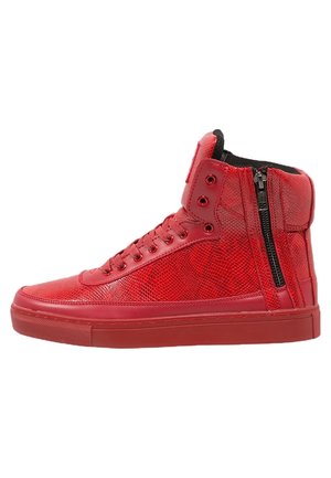 Czerwony wysokoprofilowy sneaker z teksturowanym wzorem, sznurowany z przodu, z wyściełanym kołnierzem i czarnym bocznym zamkiem błyskawicznym, pokazany z profilu na białym tle.